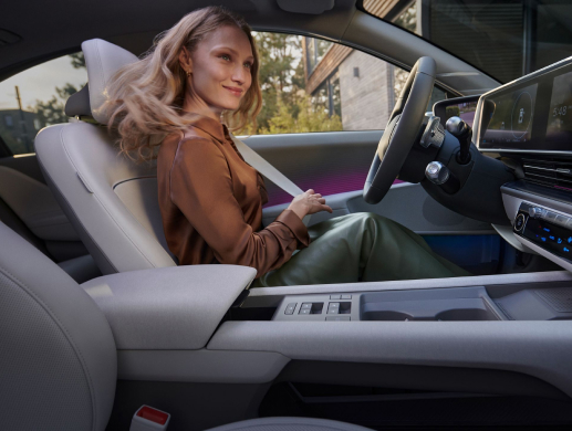 woman with brown t-shirt and green skirt in the driver’s seat of the Hyundai IONIQ 6 